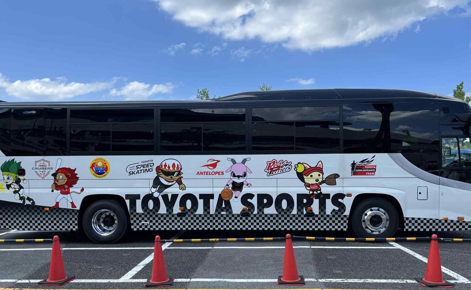 トヨタ自動車のチームバスには多彩な競技チームのロゴが-大島和人撮影
