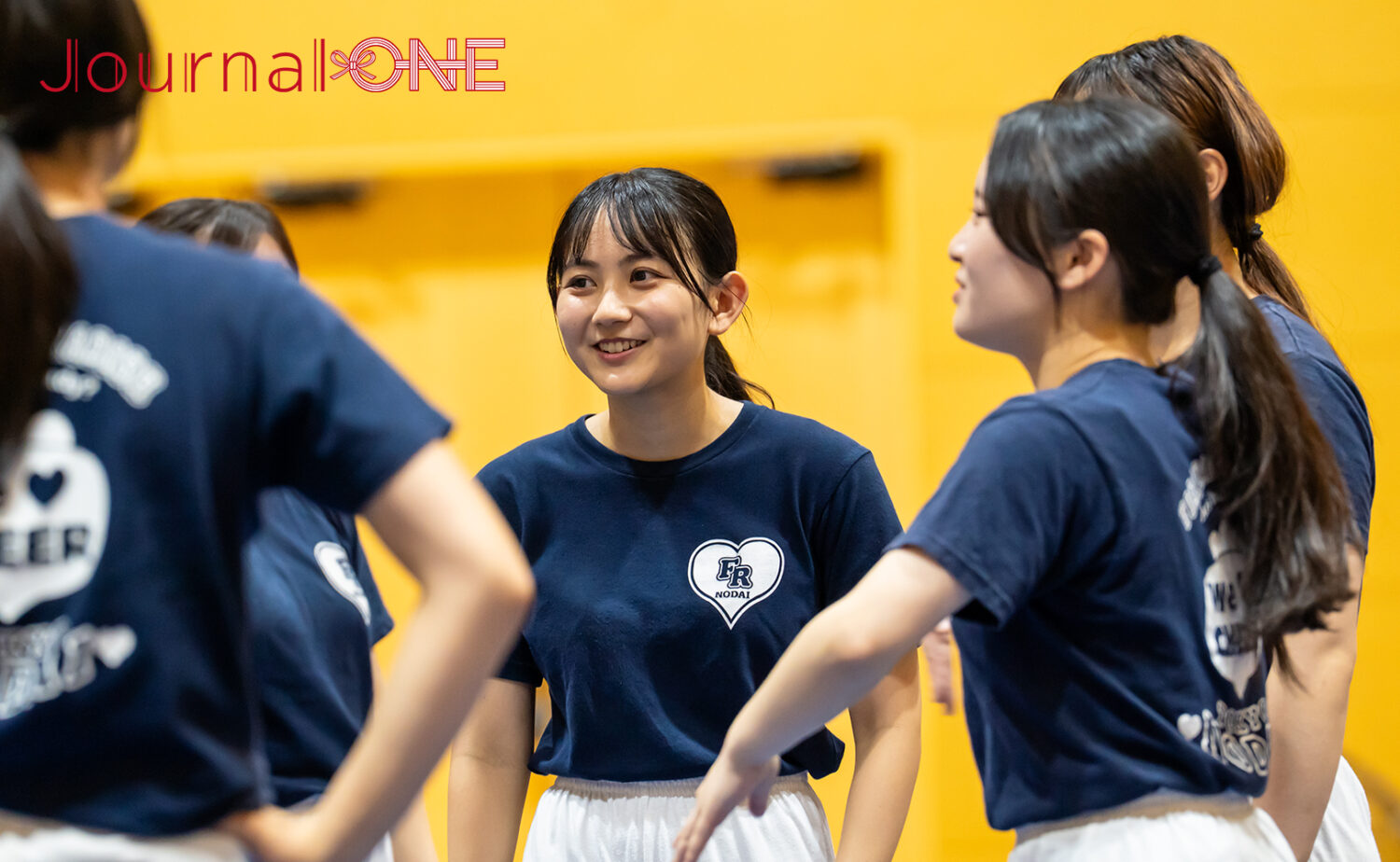 東京農業大学チアリーディング部の学生同士が練習中に声をかけ合う様子(2025年8月8日