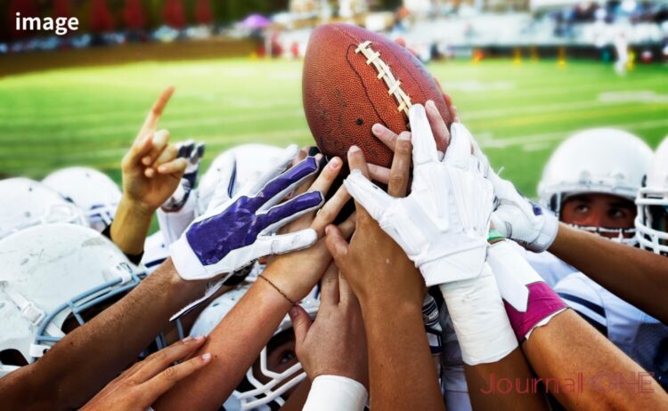 Xリーグ準々決勝の熱気を象徴するアメリカンフットボール選手のボールを囲む手