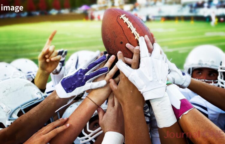 Xリーグ準々決勝の熱気を象徴するアメリカンフットボール選手のボールを囲む手