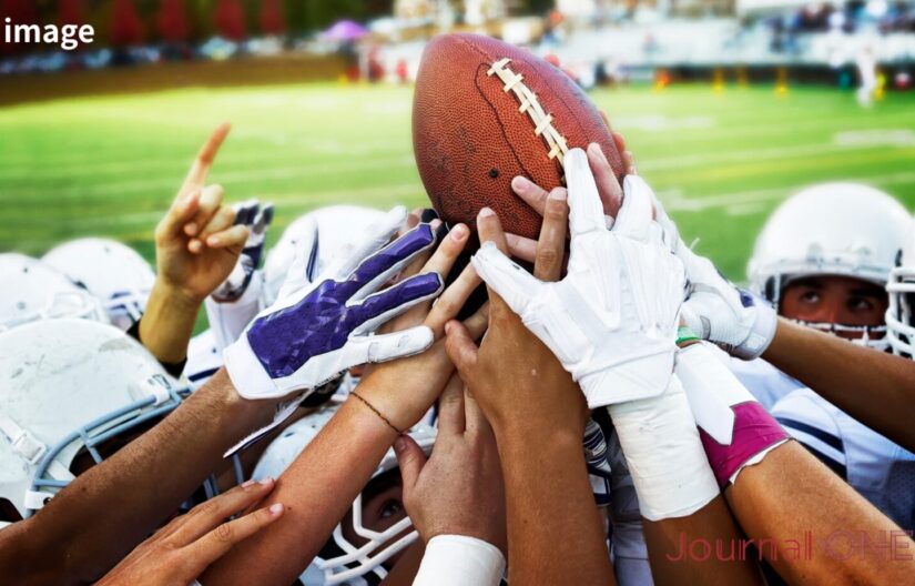 Xリーグ準々決勝の熱気を象徴するアメリカンフットボール選手のボールを囲む手