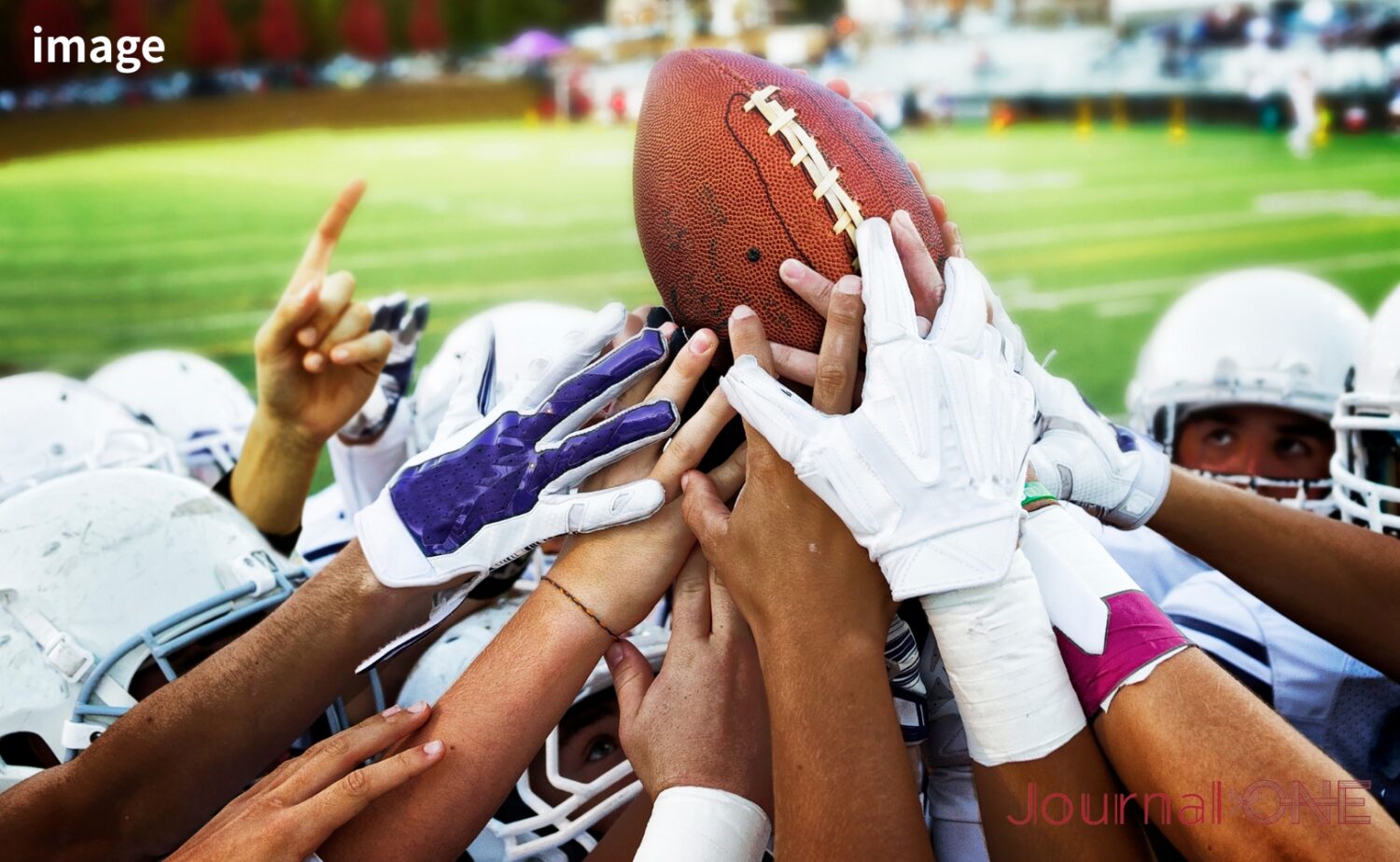 Xリーグ準々決勝の熱気を象徴するアメリカンフットボール選手のボールを囲む手