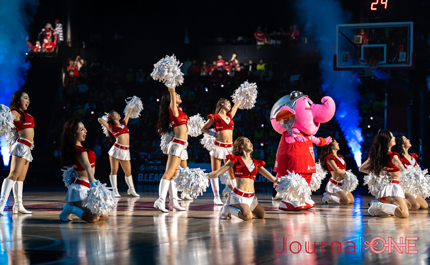 ららアリーナ 東京ベイのコート上で、千葉ジェッツのマスコット「ジャンボくん」とフライトクルーチアリーダー「STAR JETS」が共にパフォーマンスを披露し、会場を盛り上げる様子。